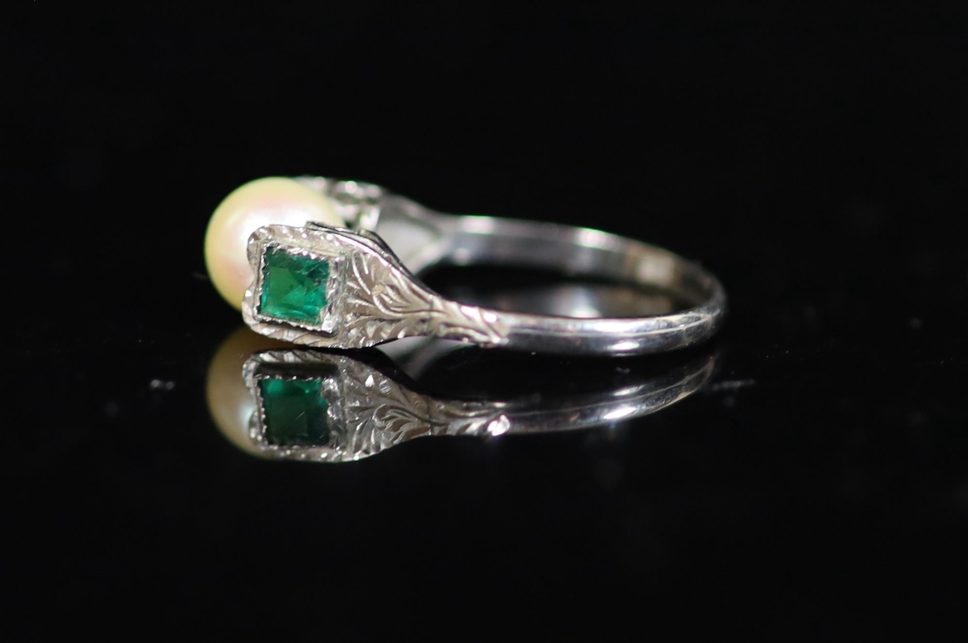 A mid 20th century white gold, cultured pearl and emerald set three stone ring